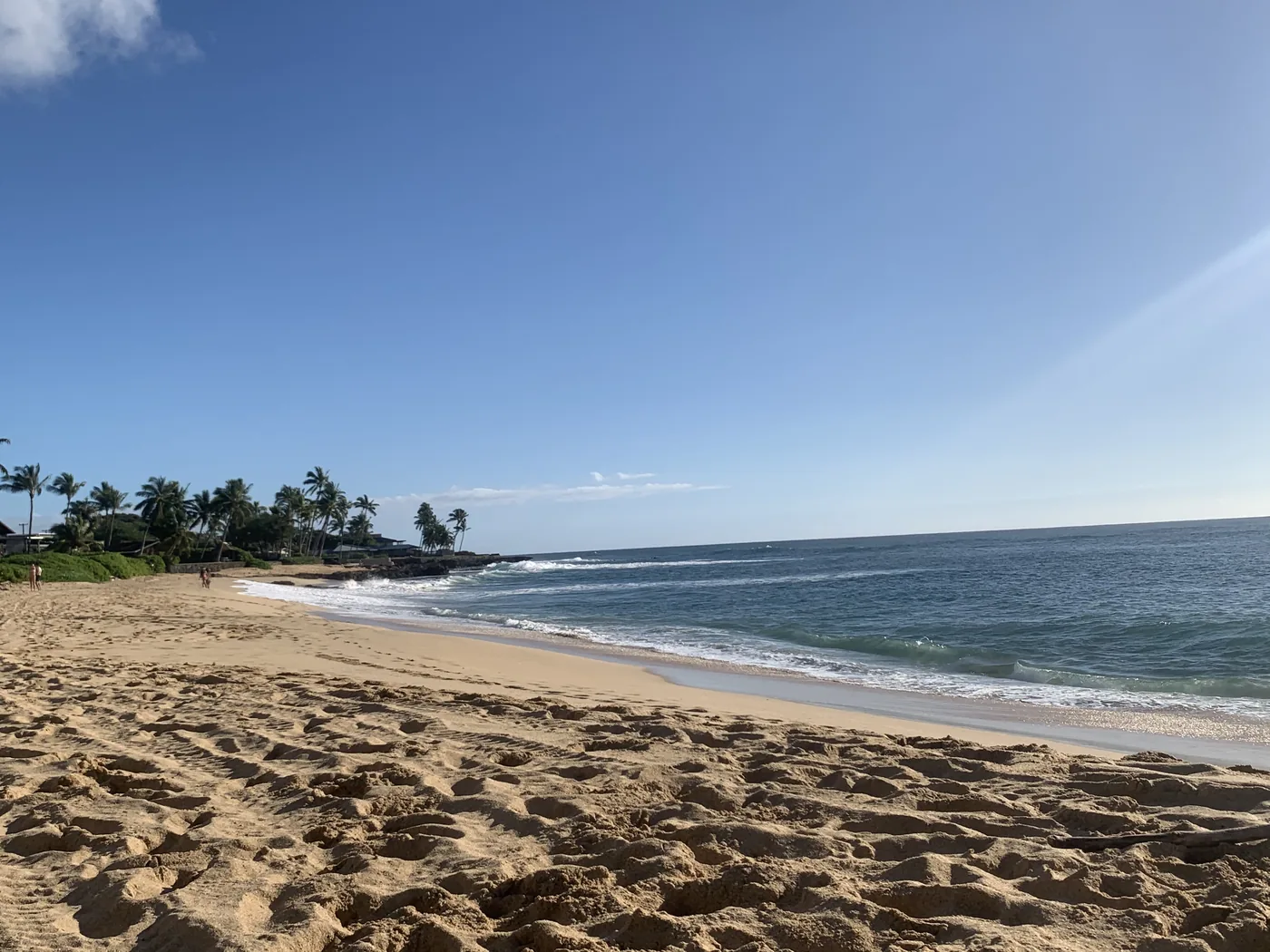Wide sandy beach with calm blue water